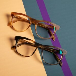 Close-up of two trendy spectacles on vibrant pastel surfaces.